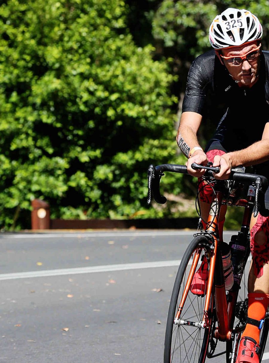 Giuseppe Gambarini pedala con il pettorale 325 nella frazione di ciclismo del triathlon Hervey Bay 100